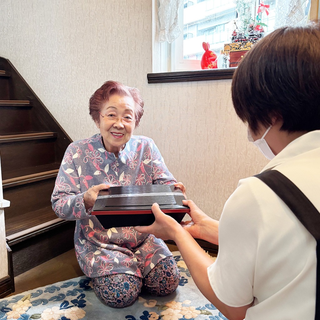 彩り豊かなお弁当と笑顔の高齢者